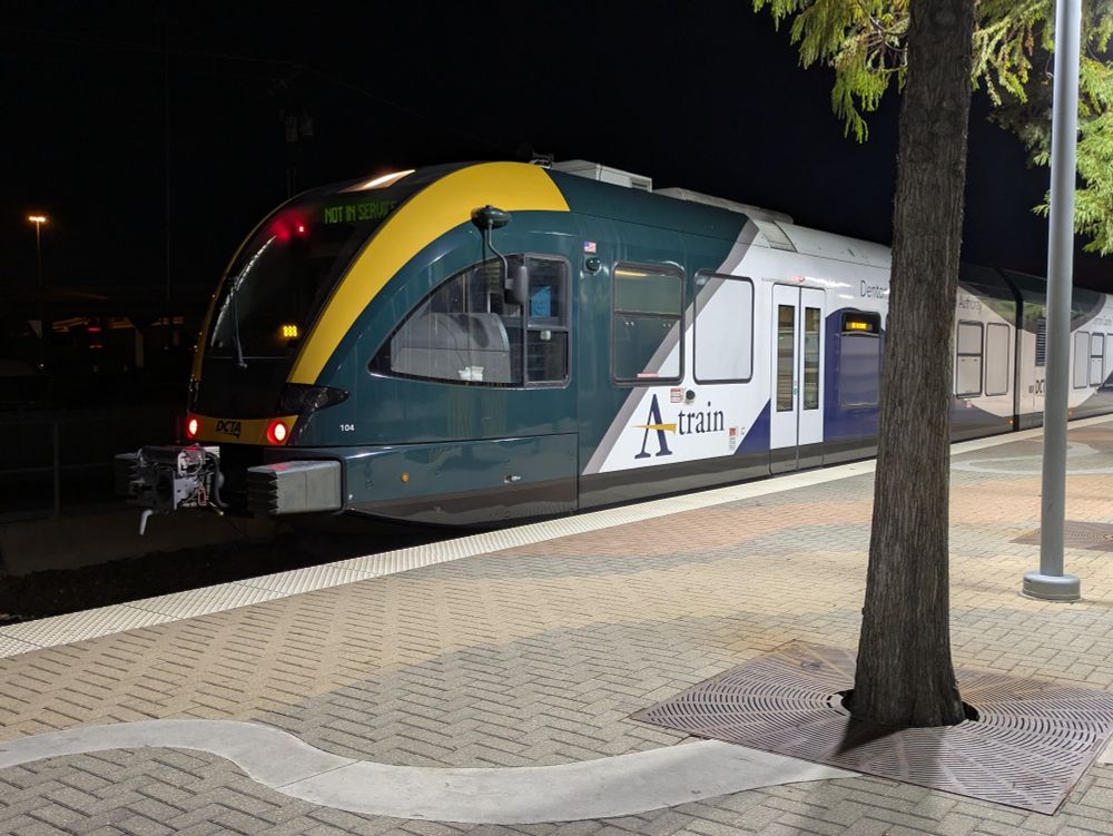 A picture of DCTA's A-Train on the Trinity mills station with via signs that say Not in service