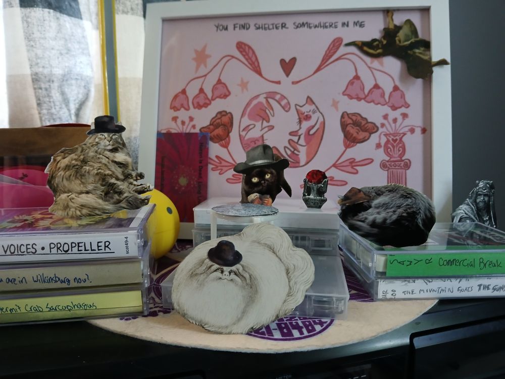 the 4 cats are placed in a scene with more overhead lighting, still playing contract bridge