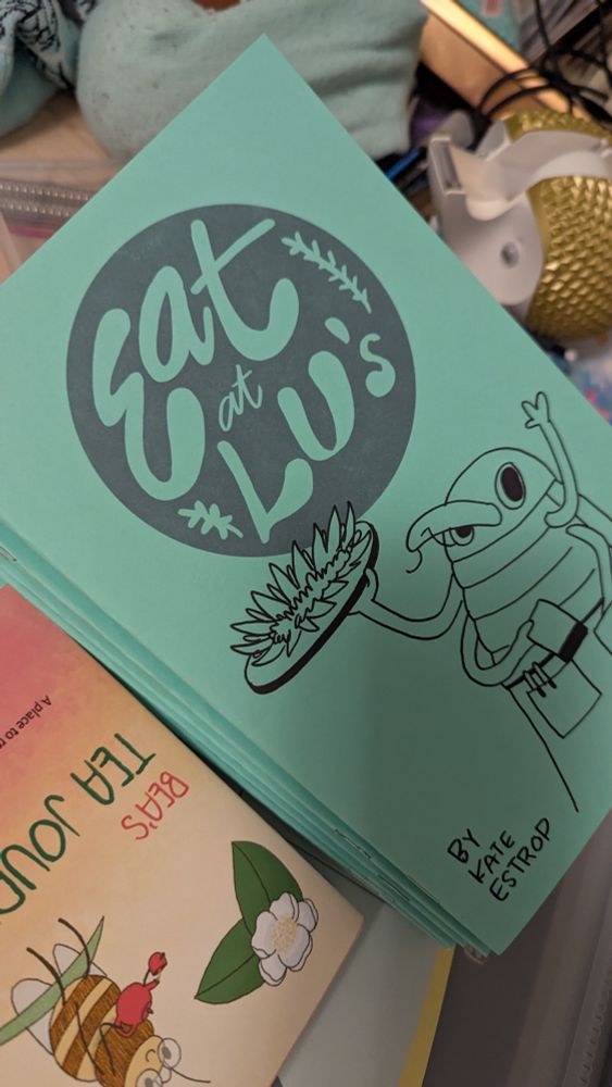 A stack of my story comic called Eat at Lu's, which has a cartoon weevil holding a food tray above her head with the top of a flower on it, face-up. She's waving. She's also holding a notepad. 