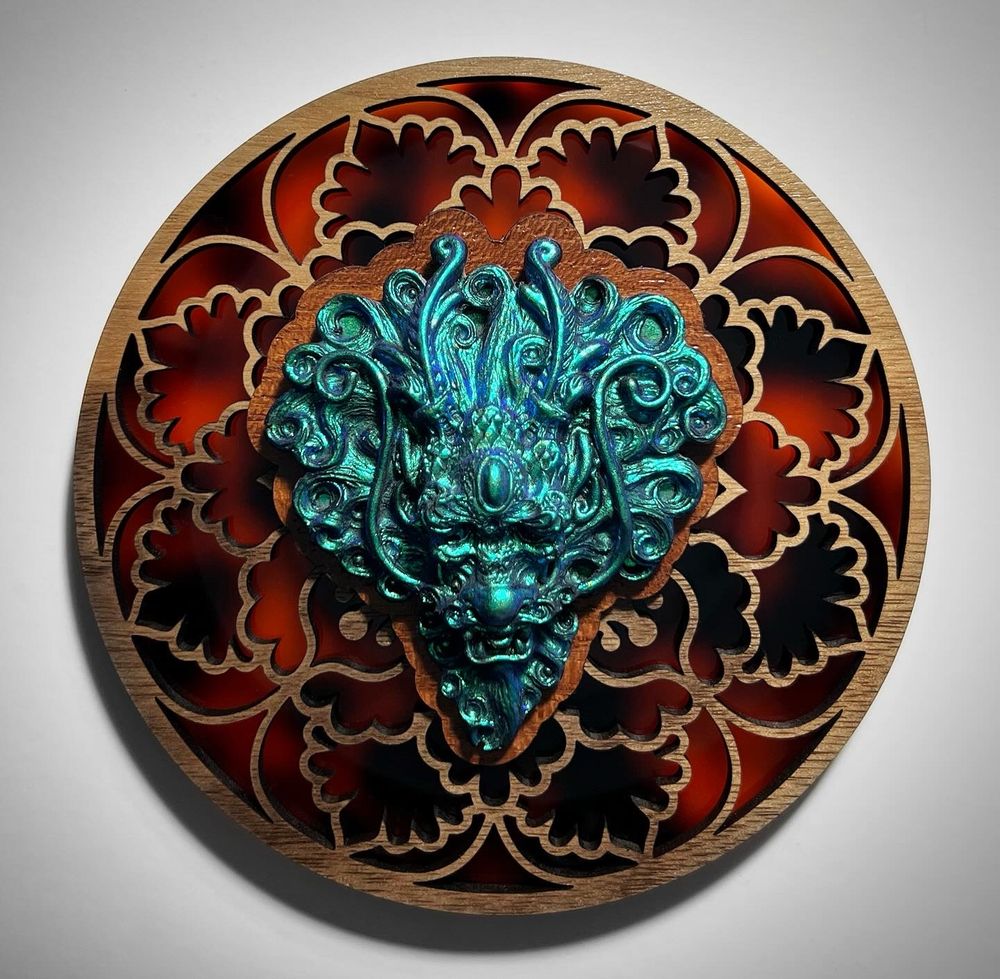 A metallic teal Eastern style dragon head cast in resin, on a laser cut wood and faux tortoise shell acrylic backer. 
