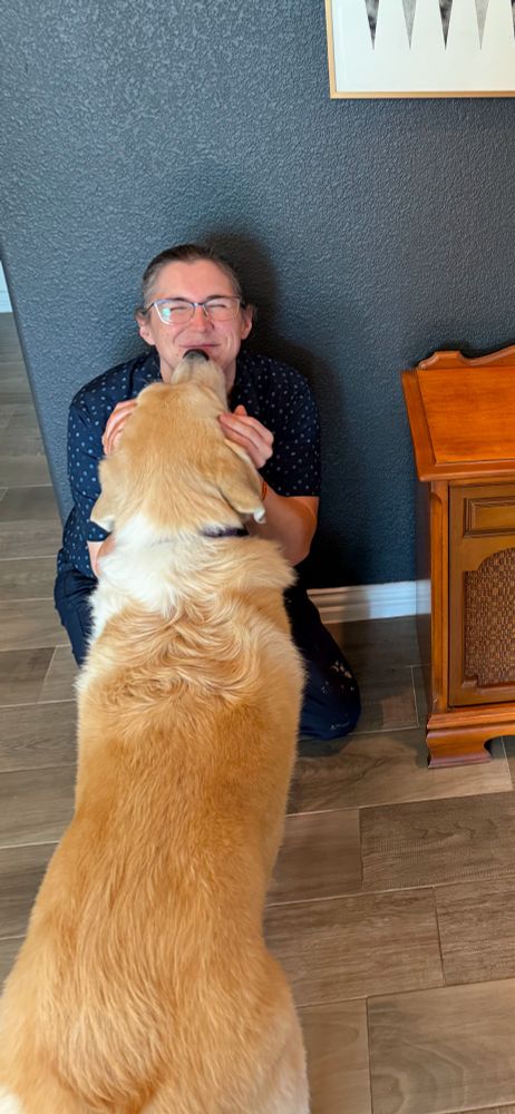 Yellow lab giving repair woman licks on on chin. 