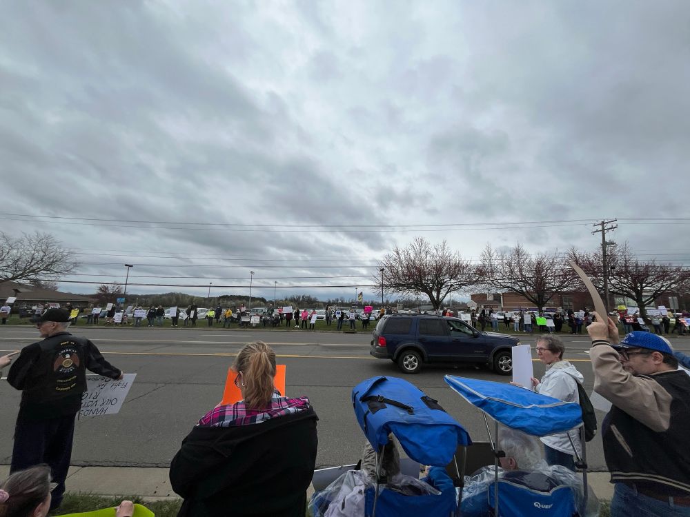 View of the crowd across the street as cars drive by and honk in solidarity.