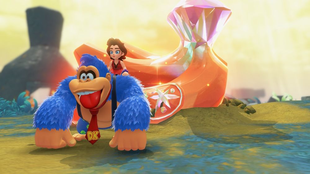 Screenshot of Donkey Kong and Pauline from Donkey Kong Bananza. They’re standing in front of a bunch of orange hued crystal bananas. And DK’s fur is blue. 