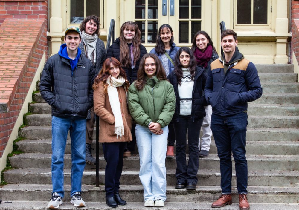 8 members of the Swann lab standing in front of Gerlinger Hall on University of Oregon campus