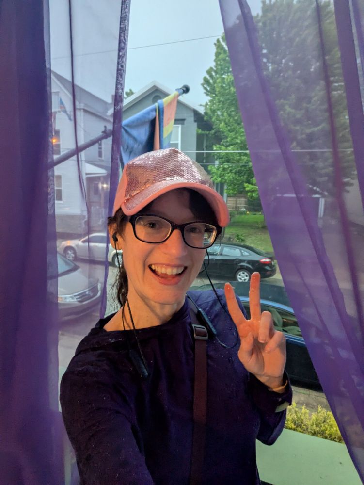 Woman on her porch, drenched from the heavy thunderstorm behind her.