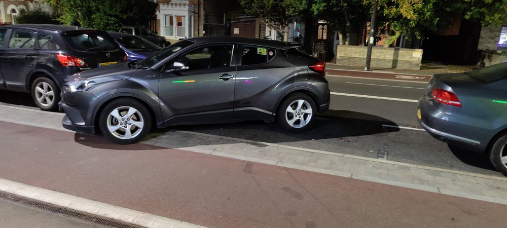 A car parked partially on a bike lane