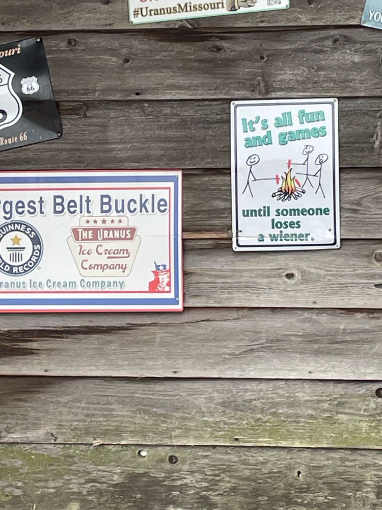 Picture of a shining the wall. The sign has a picture of people roasting hot figs over a fire. The words say:
It’s all fun and games until someone loses a wiener 