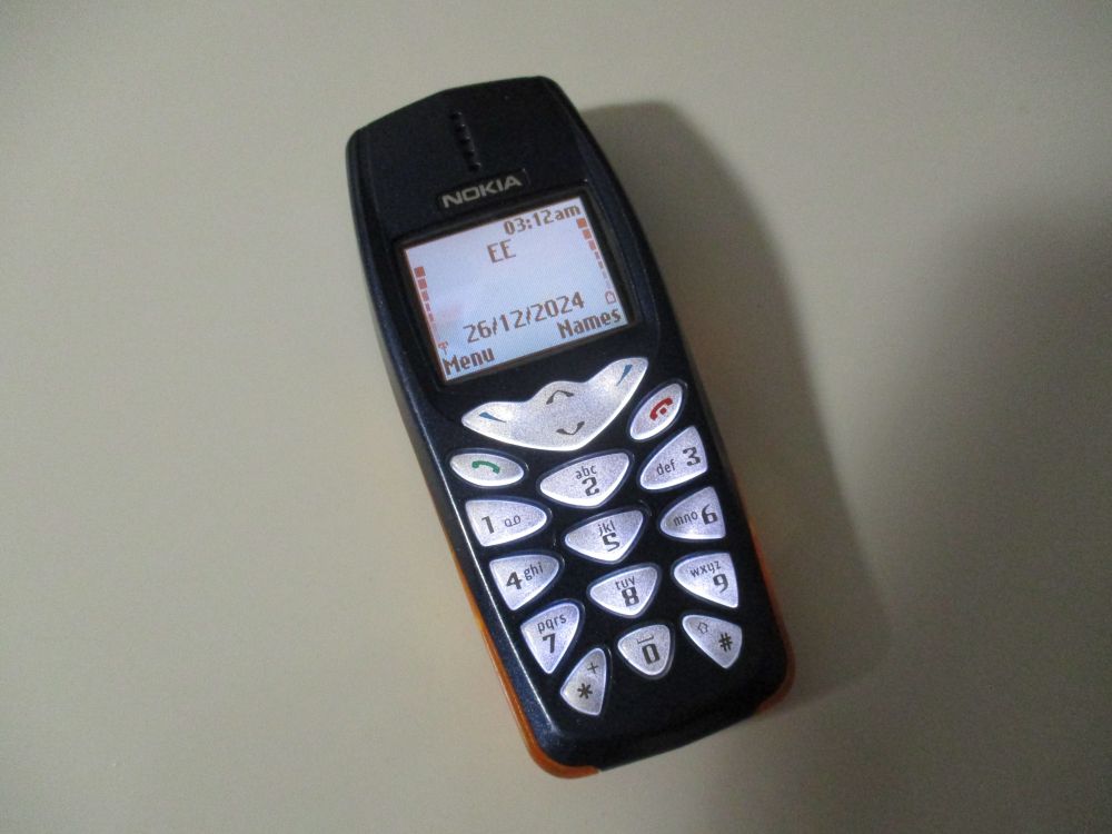 A dark blue Nokia 3510i, displaying the idle screen with the red colour scheme and "City" wallpaper applied.