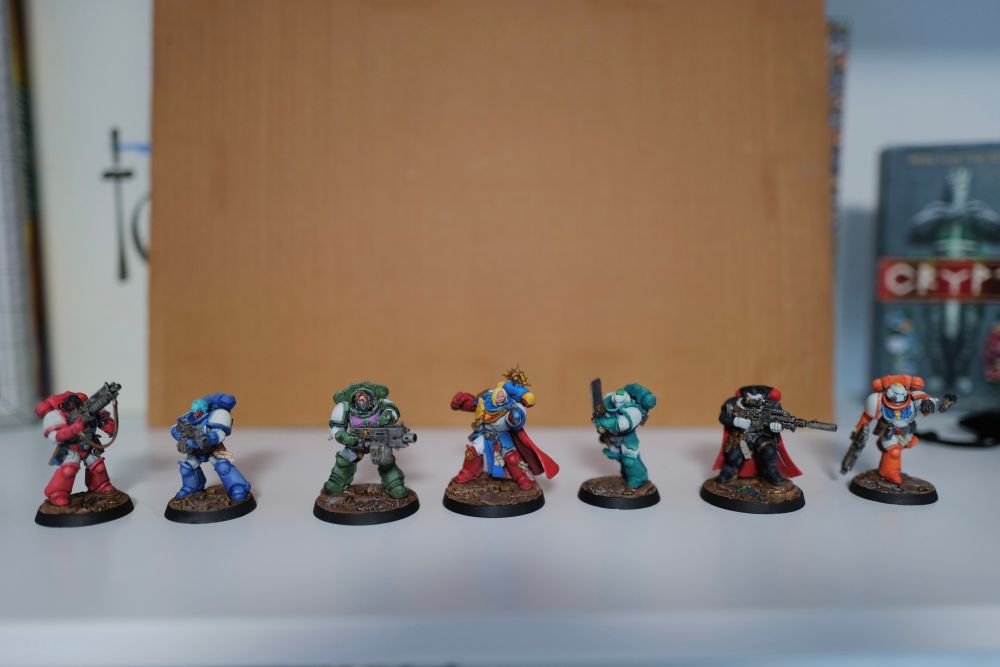 A picture of the Space Marines from the Warhammer 40k: Kill Team starter set. The marines are painted in a scheme that roughly matches the characters from Sailor Moon, and some of them have custom-printed female heads.