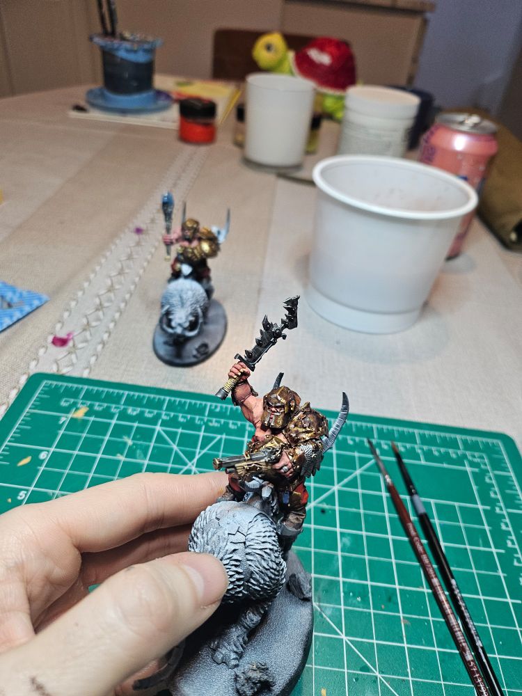 A Warhammer Age of Sigmar Ogor Mournfang Rider miniature. The rider is painted with bronze armor, red pants, and Caucasian skin tone. The mount is unpainted.
