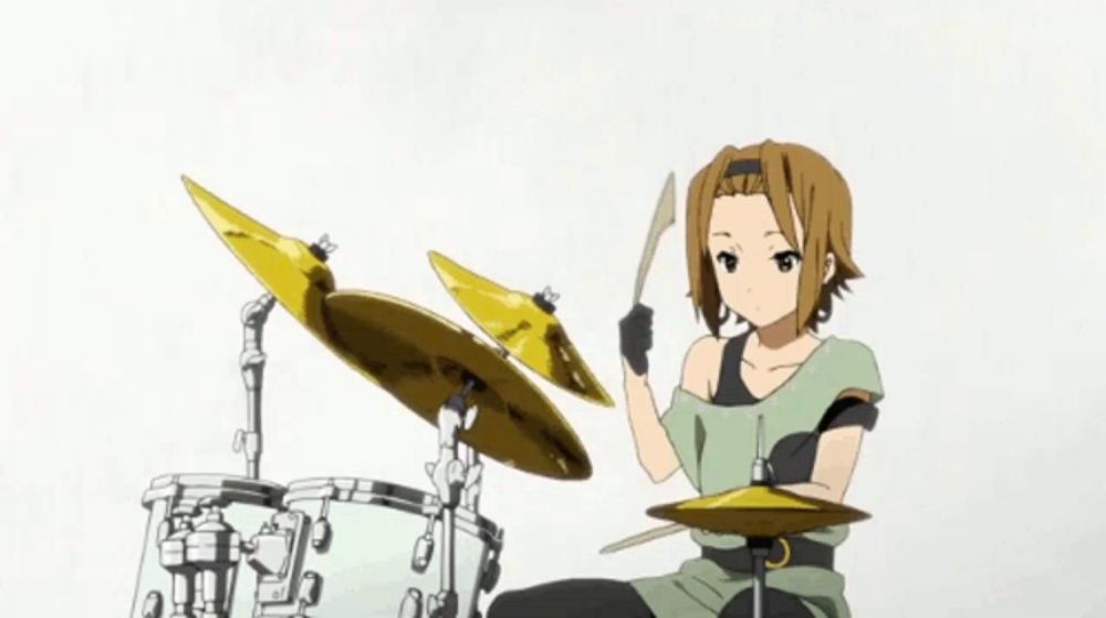 a girl is playing a drum set with a cymbal