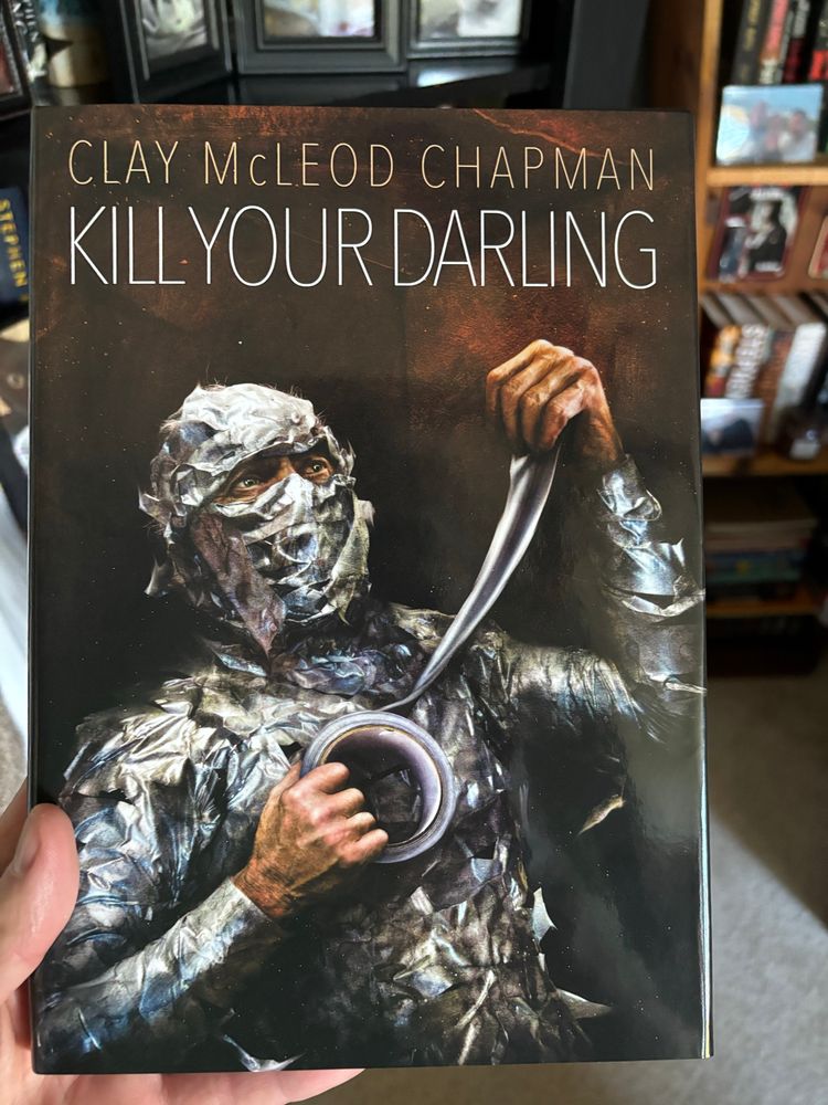 Chapman’s KILL YOUR DARLING,
man covered in duct tape, stretching more off the roll.