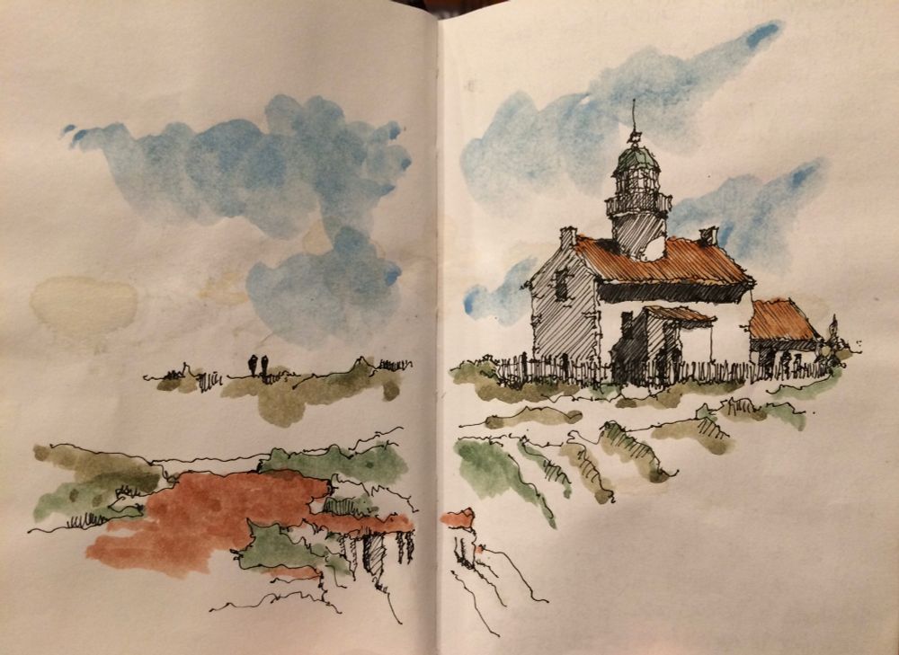 Ink and watercolor sketch of the Old Point Loma Lighthouse, spread over two pages in a sketchbook. Scene shows the white lighthouse with a teal roof tower and brownish red lower roof, green and brown path in the foreground and cloudy blue sky beyond.