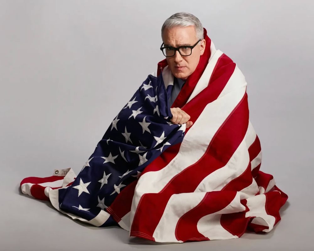 keith olbermann snuggling inside the american flag like it's a big blanket
