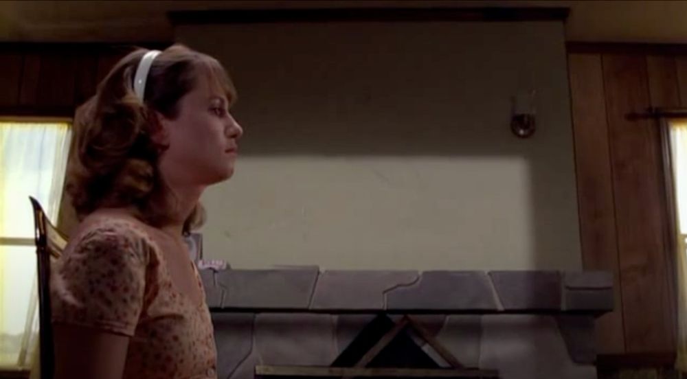 ed from raising arizona sitting motionless in profile as h.i. walks in and out of frame with various guns