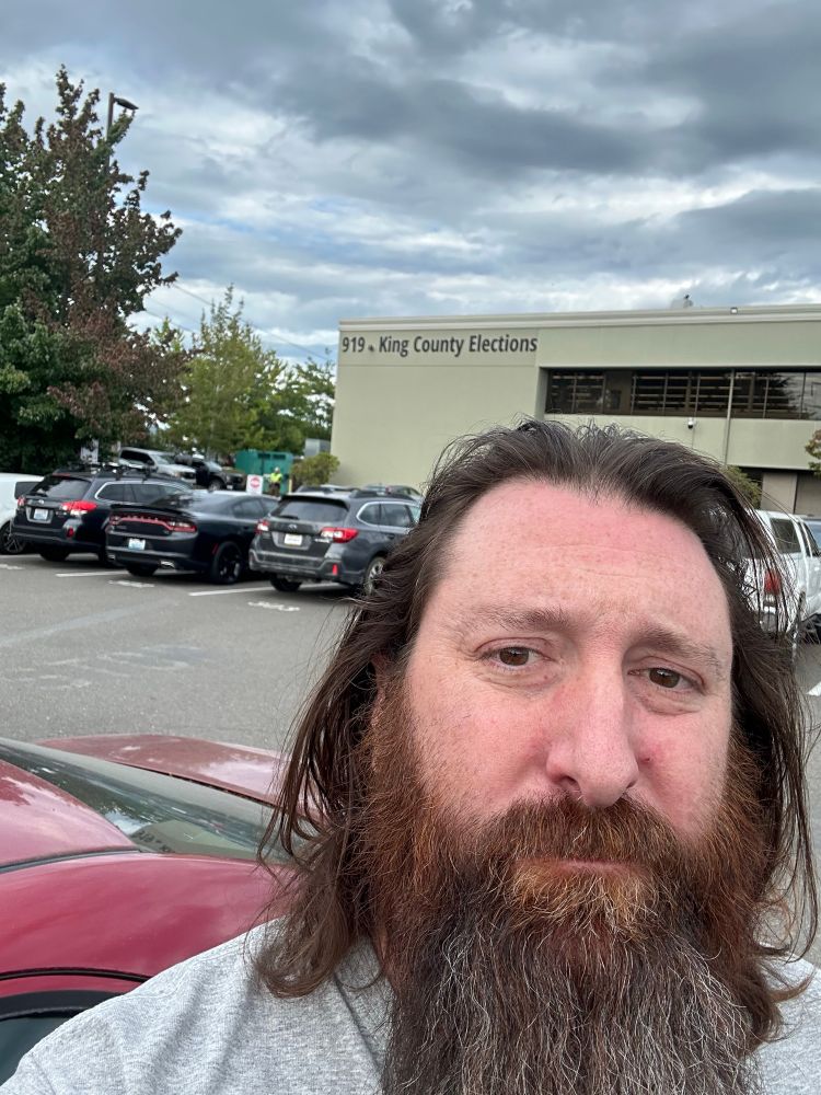 Matthew standing in front of the King County Elections since he lost his ballot… again.