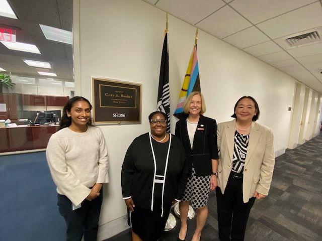 During ASBMB's Hill Day four people smile and pose for a photo in front of Sen. Cory Booker's office. 