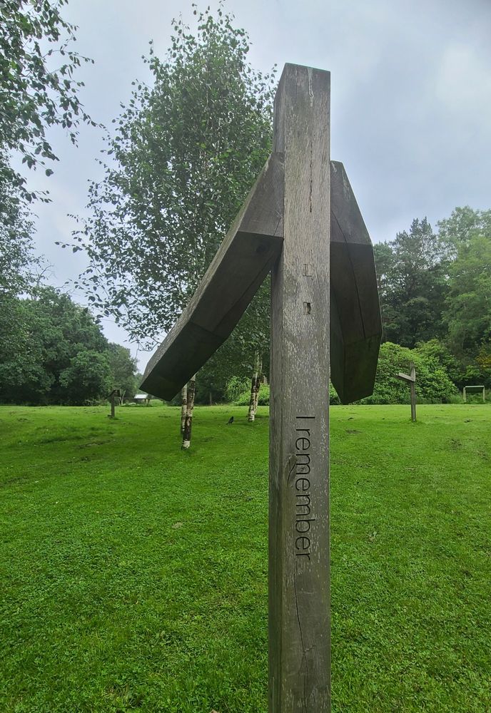 Part of "I remember" public Covid-19 memorial in Pollok Park, Glasgow on the form of anthropomorphic tree support posts inscribed "I remember"