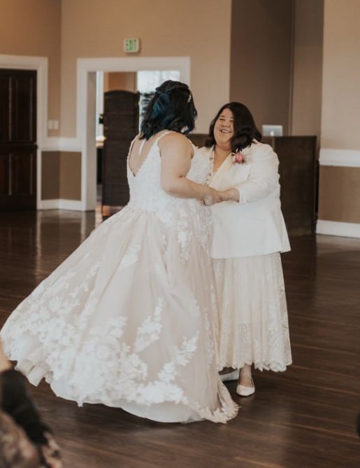 Mid-dance photo from first dance of Shannon and Janette’s wedding. Shannon is facing away from camera and dress is slightly off the ground due to mid-spin 