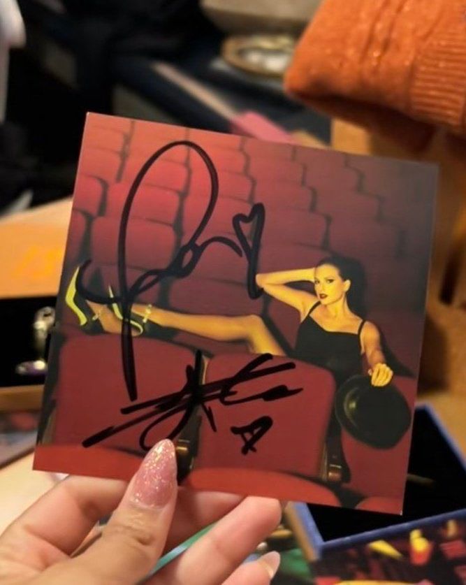 a picture of a showgirl insert signed by taylor swift and travis kelce