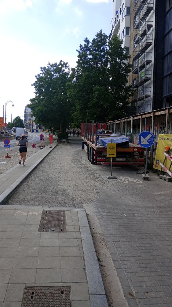 Une photo de la voie parallèle du square Sainctelette à Bruxelles (Sainte Klette pour les intimes)  devant le chantier de KANAL le futur centre Pompidou Bruxellois.

On distingue à droite la rangée l'immeuble de KANAL puis celui du Kaaitheater. Le trottoir est équipé d'une galerie temporaire protégeant les poéton, un remorque de camion  est garée sur la droite le long de la galerie. Un panneau jaune invite les cyclistes à se déporter sur la gauche  vers le morceau de voie restant libre. Celle ci est recouverte de gravillons.