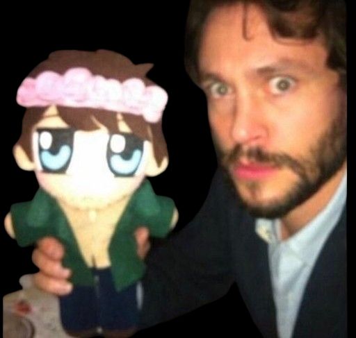 hugh dancy holding anime will graham plush. he is very scared.