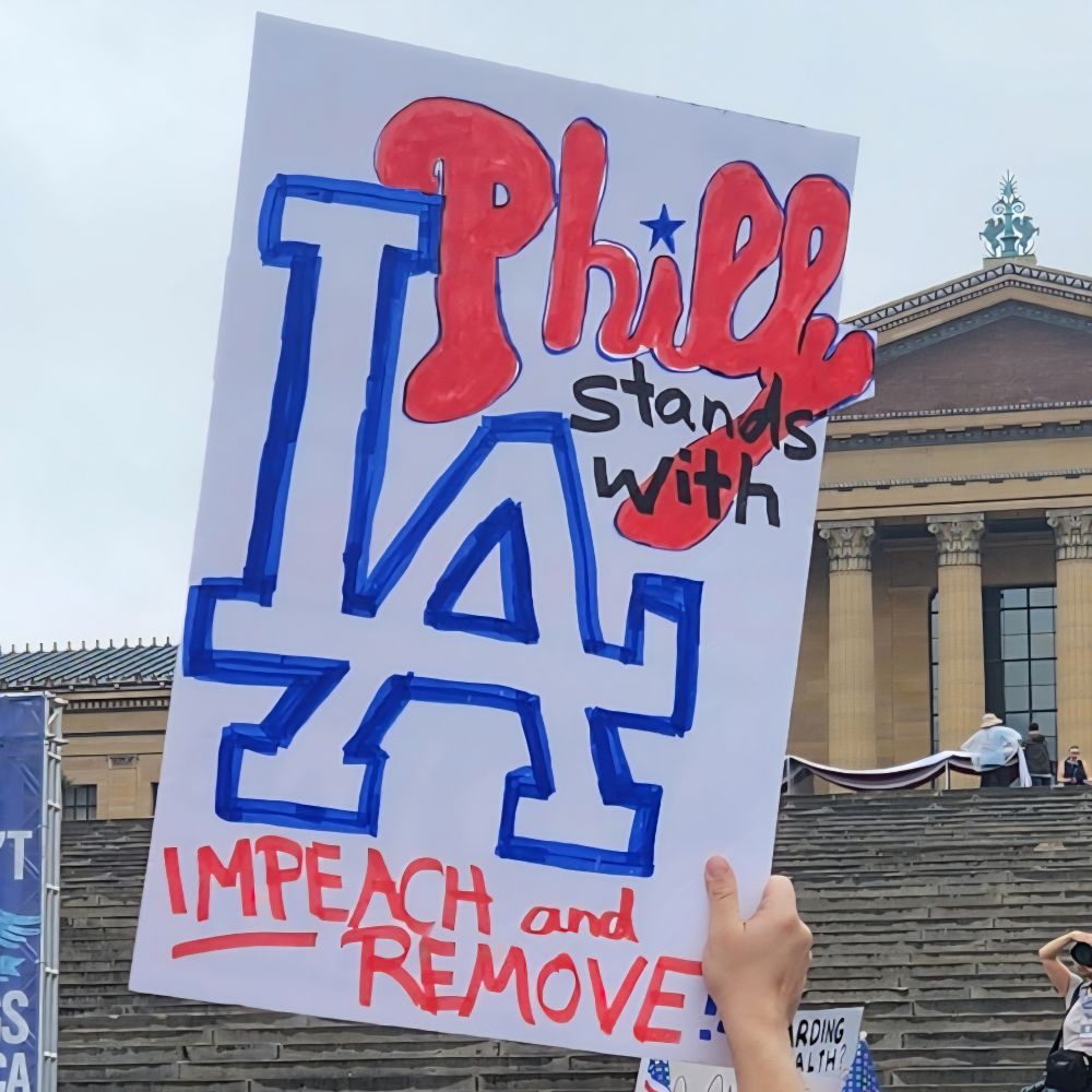 Sign in front of Philadelphia Museum of Art reading "Philly stands with LA Impeach and Remove" Philly is written in the style of the Phillies and LA is the logo for the Dodgers