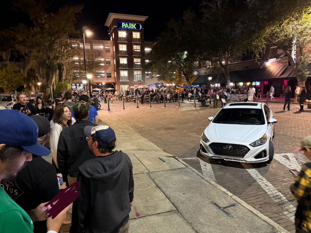 A line of people wrapped around a the block at night waiting to enter Loosey’s in Gainesville, FL ahead of the Pool Kids mystery set.