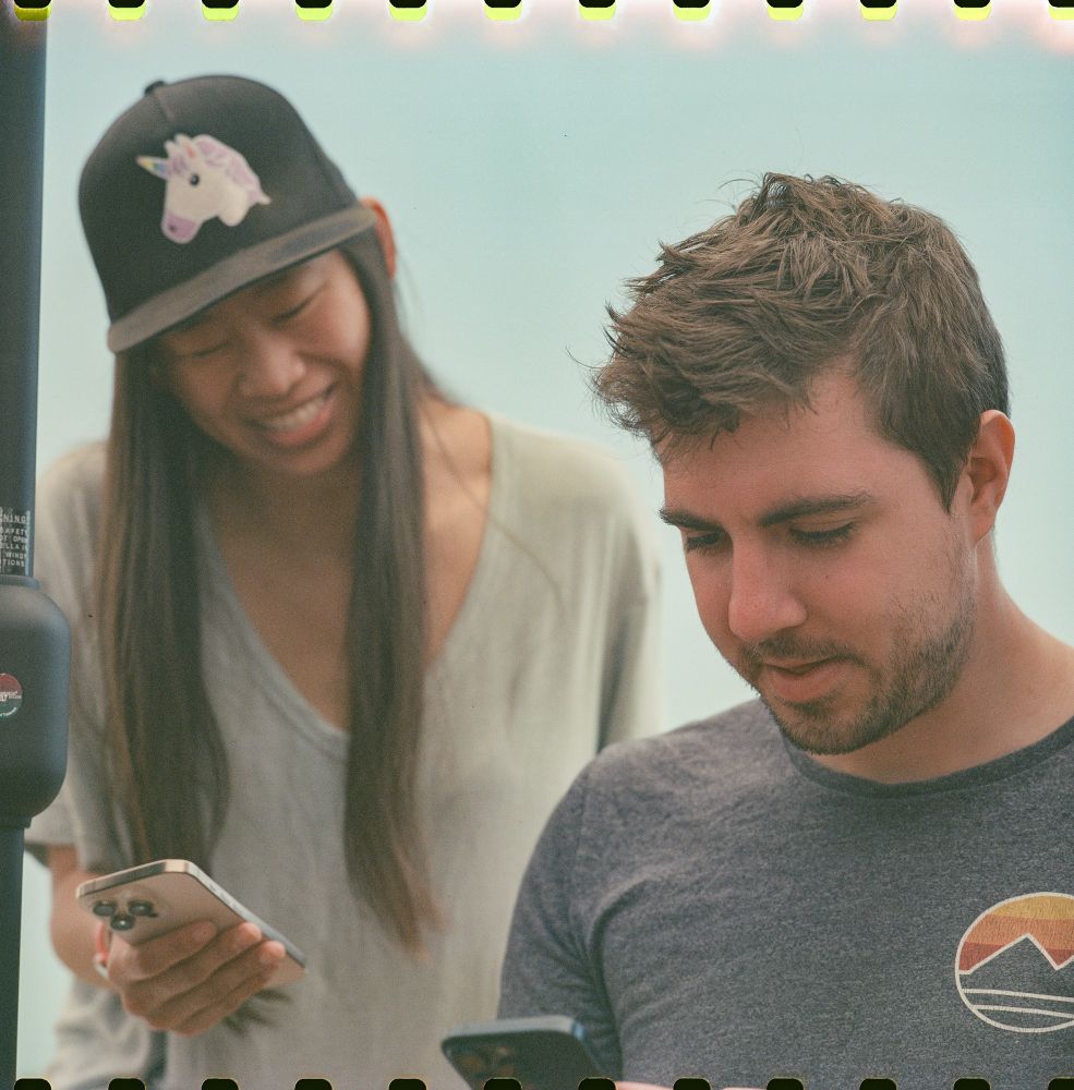 Mikaela and Christian looking at their phones