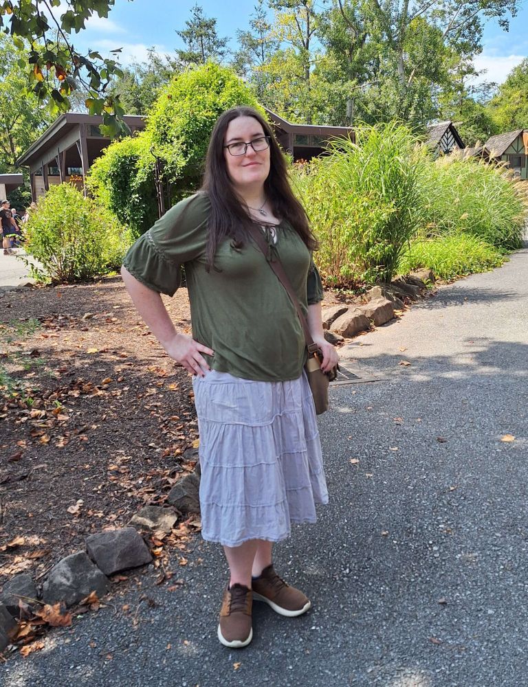 A picture of a woman in a blouse and skirt at the fair. 