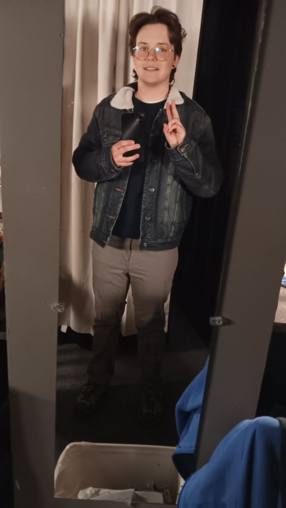 stupid white trans masculine guy giving peace sign while he tries to not have a panic attack about being asked to understudy 20 minutes before the last run of a holiday show