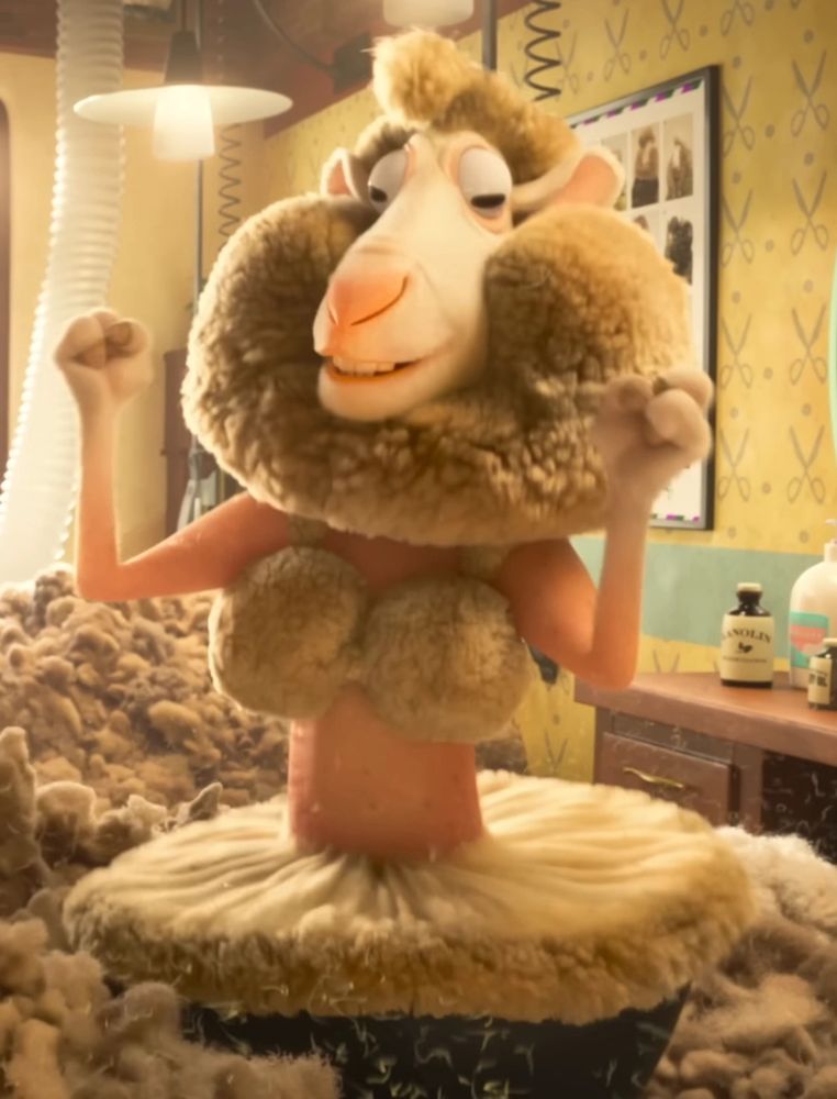 a sheep with pink skin white wool. his body between his neck and his hips is free of wool, save for a few bits that resemble a bra and tutu. he is standing in a barber shop surrounded by sheared wool and holding his hands up in excitement as he smiles over his new look.