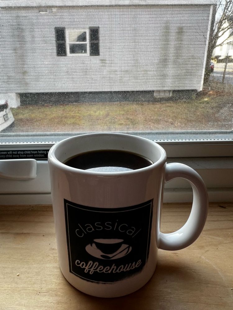 An image of a coffee cup on a windowsill