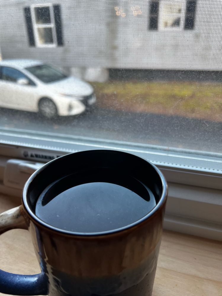 An image of a coffee cup on a windowsill