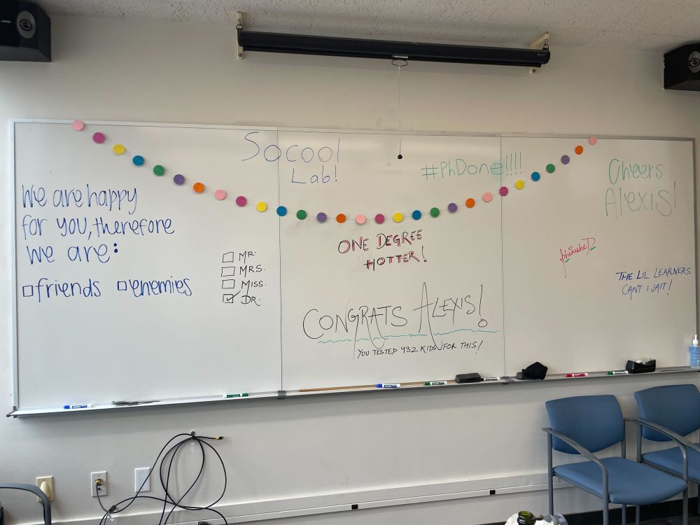 White board messages to Alexis from labmates & friends