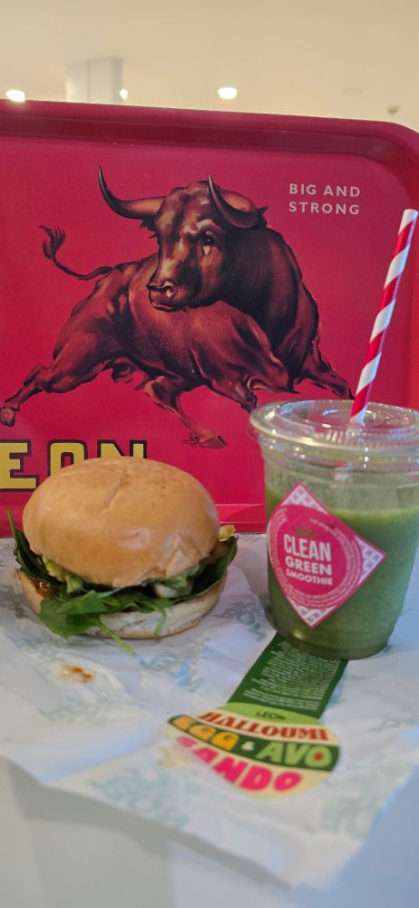 Halloumi, Egg and Avo Sandwich and green smoothie next to a tray with a bull illustration.