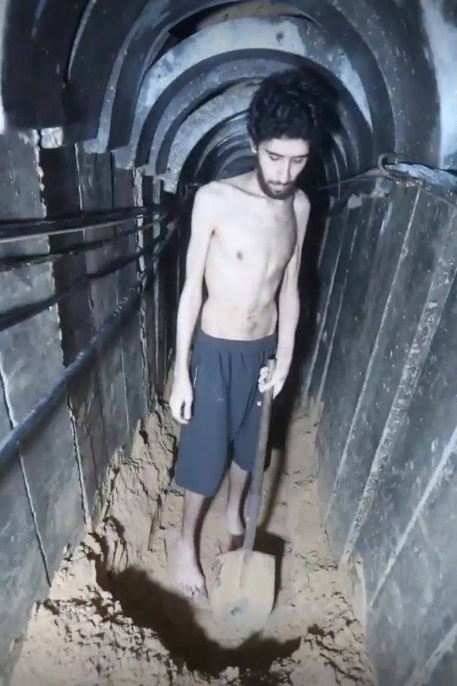 Evyatar David, 24, looks looks visibly gaunt as he ticks off days on a calendar in a narrow tunnel. Another section of the Hamas video shows him being forced to dig a hole in the ground that he says will be his grave.