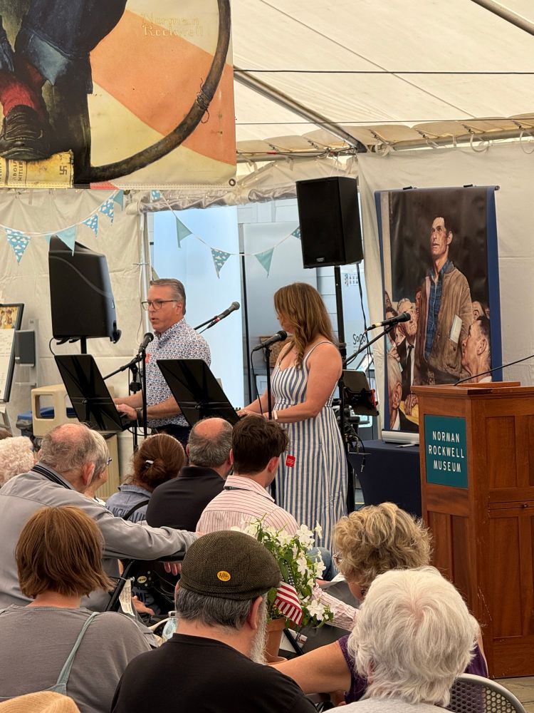 Two people standing before a crowd for a reading of the Declaration of Independence at the Norman Rockwell museum