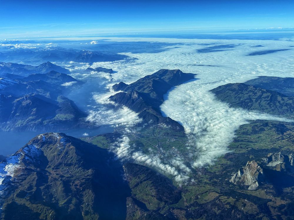 Low clouds in the valleys of the Swiss Alps, as seen from an airplane approaching Zurich