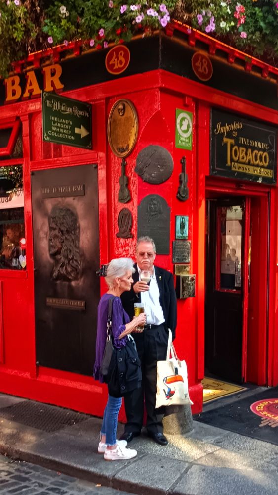 A couple drinking beer in front of the Temple Bar