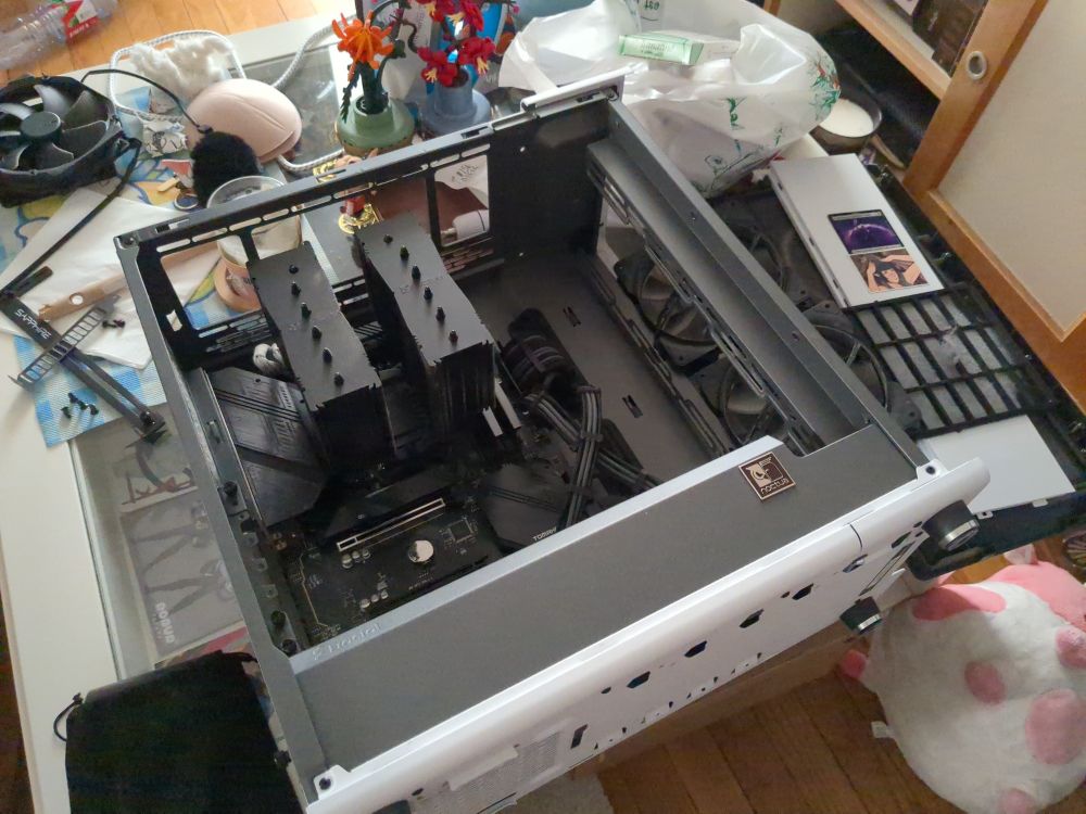 Open Desktop PC on a coffee table, multiple fans are scattered on the table