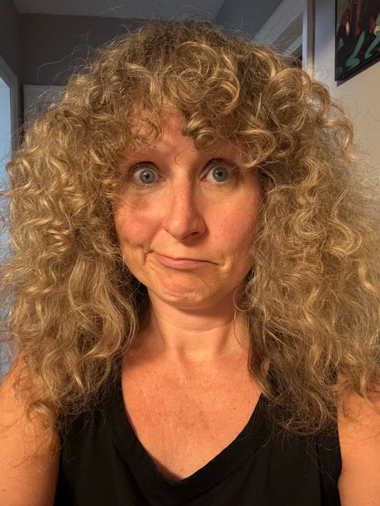 It's me, a white lady with a huge mass of curly blond hair that's particularly large and fluffy this morning. I'm making a face. 