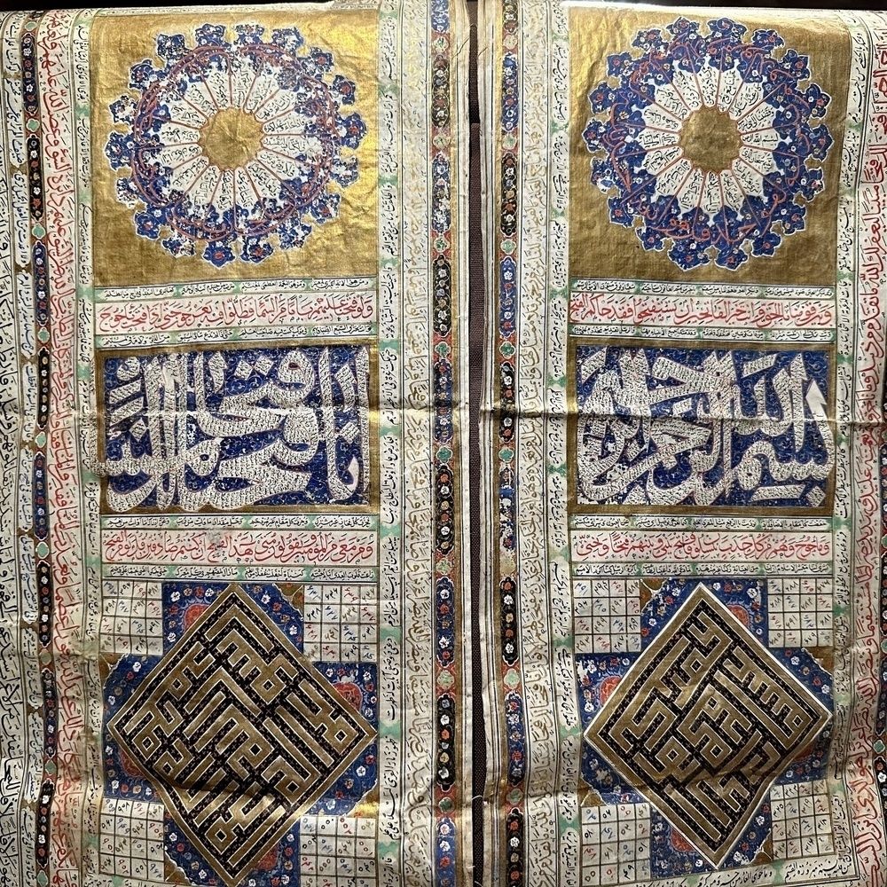 A richly decorated manuscript page features intricate geometric and floral patterns, Arabic calligraphy, and a combination of gold and blue hues.
