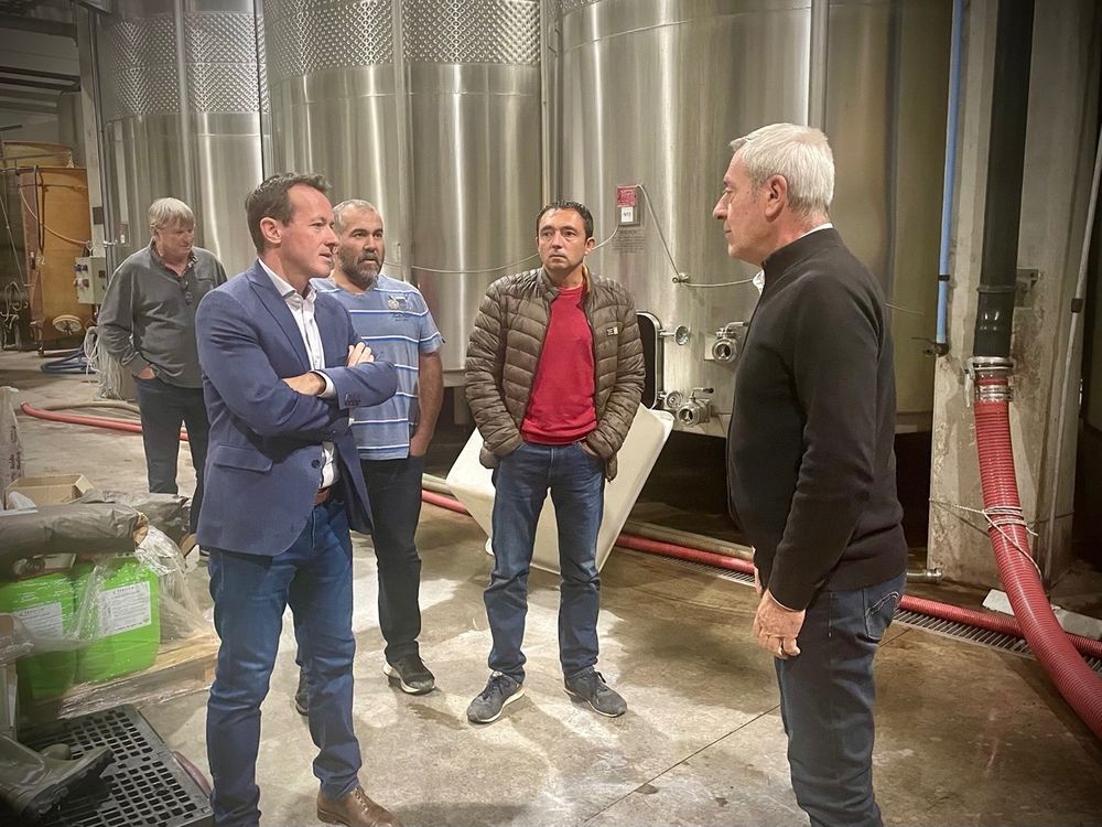 Visite à la cave coopérative de Cascastel, avec son Président et des élus locaux, devant de grandes cuves.