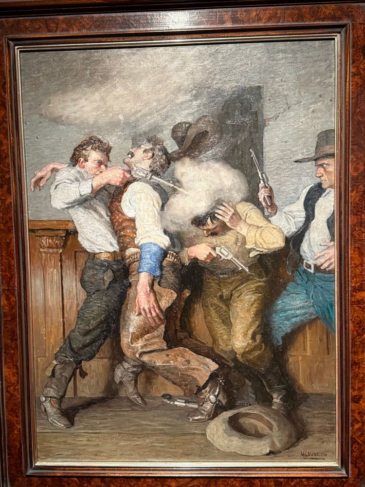 A gunfight in a saloon. One cowboy dome-pieces another, who grabs his head like “oh shit” 