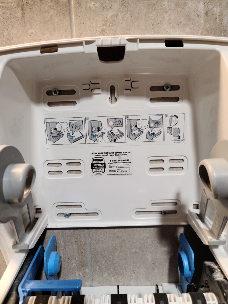 Empty paper towel roll with diagram showing how to put a new roll on dispenser.