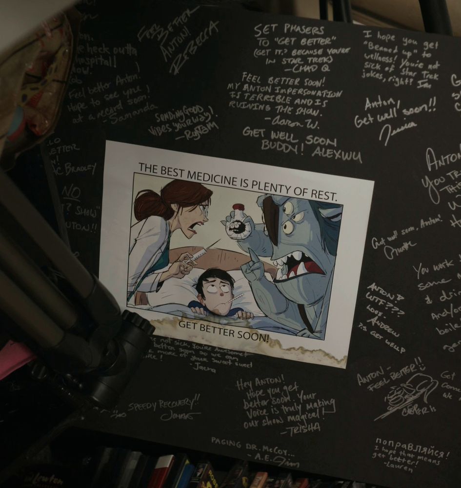 Screenshot taken from "Love, Antosha" featuring a card covered in get well soon messages. In the middle there is a face off between Barbara and Blinky over a sick and very concerned Jim. It reads "The best medicine is plenty of rest. Get better soon! It's unknown who drew it.