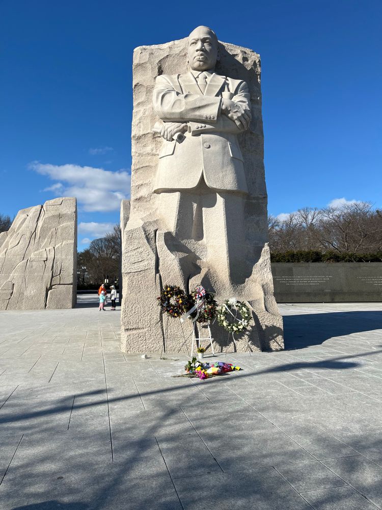 A picture of the Martin Luther King Memorial, on a clear but cold day. There are wreaths set at the base of the statue.