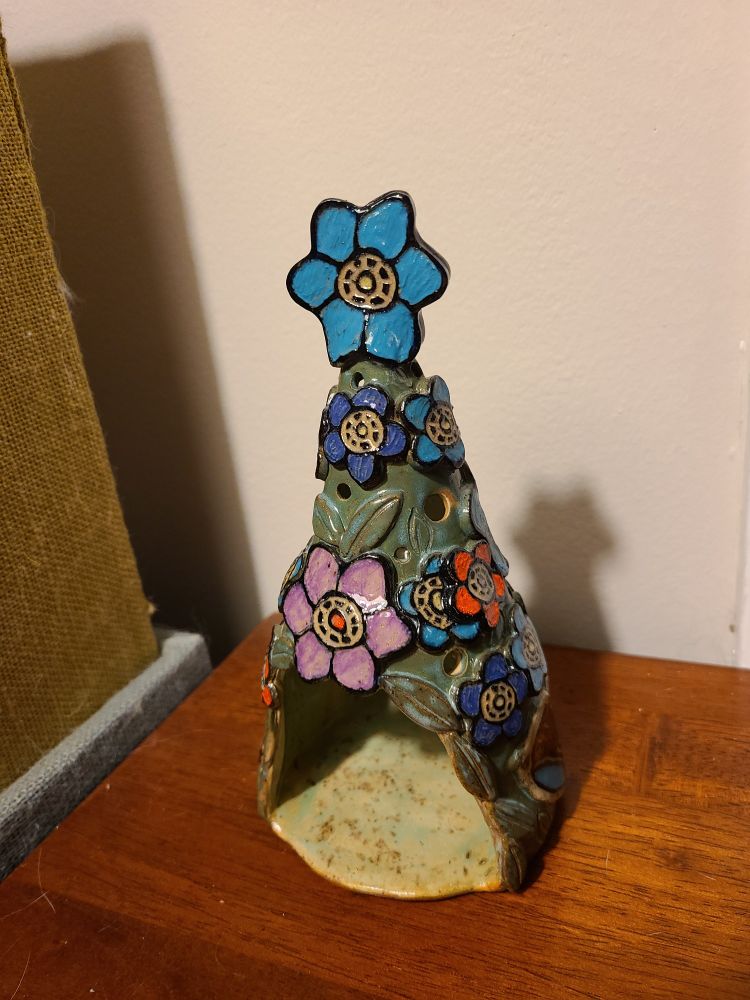 A tree shape with an opening in the bottom for a candle. Green with flowers on it.