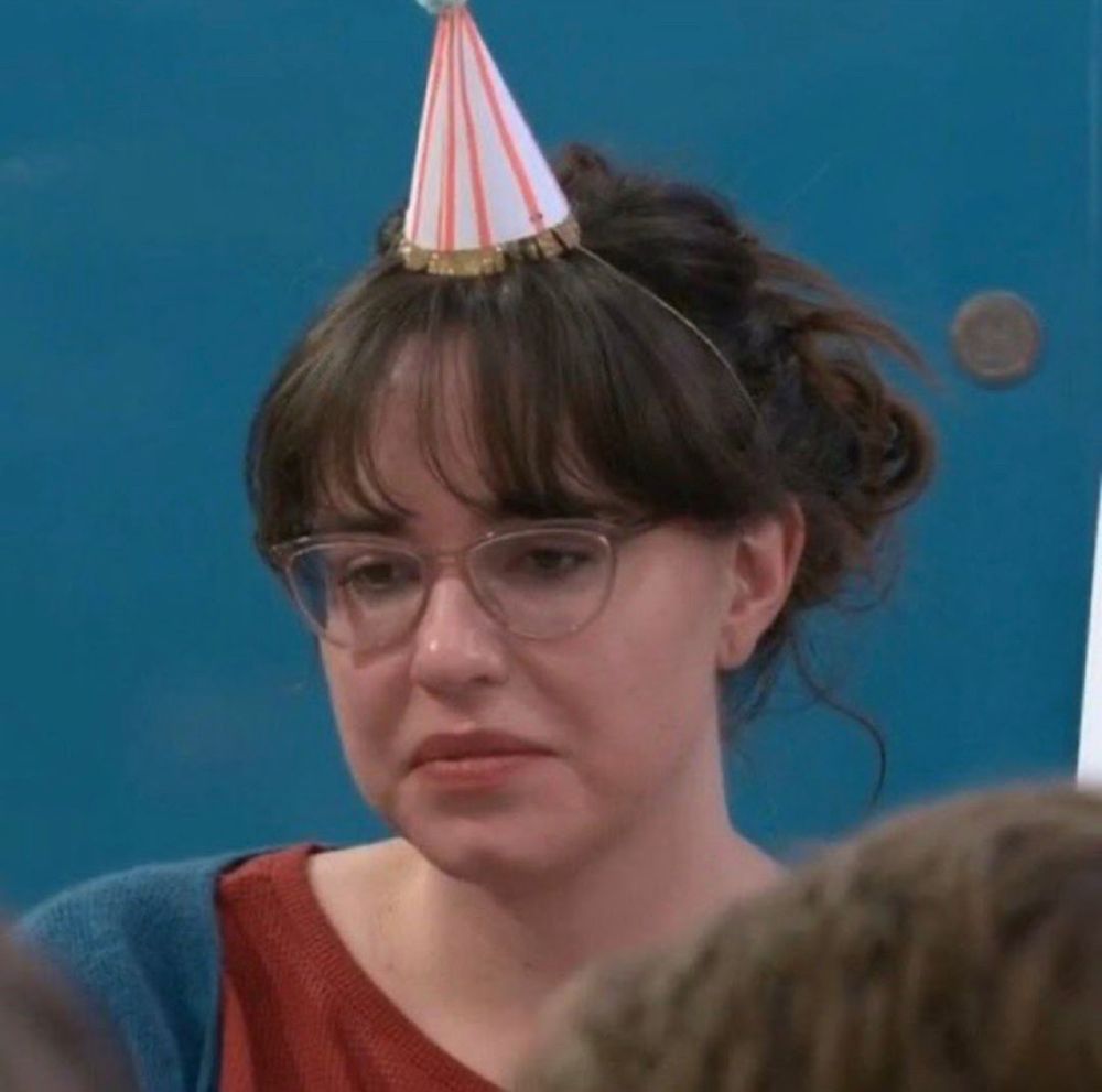 Brittney with a birthday hat on and a sad face